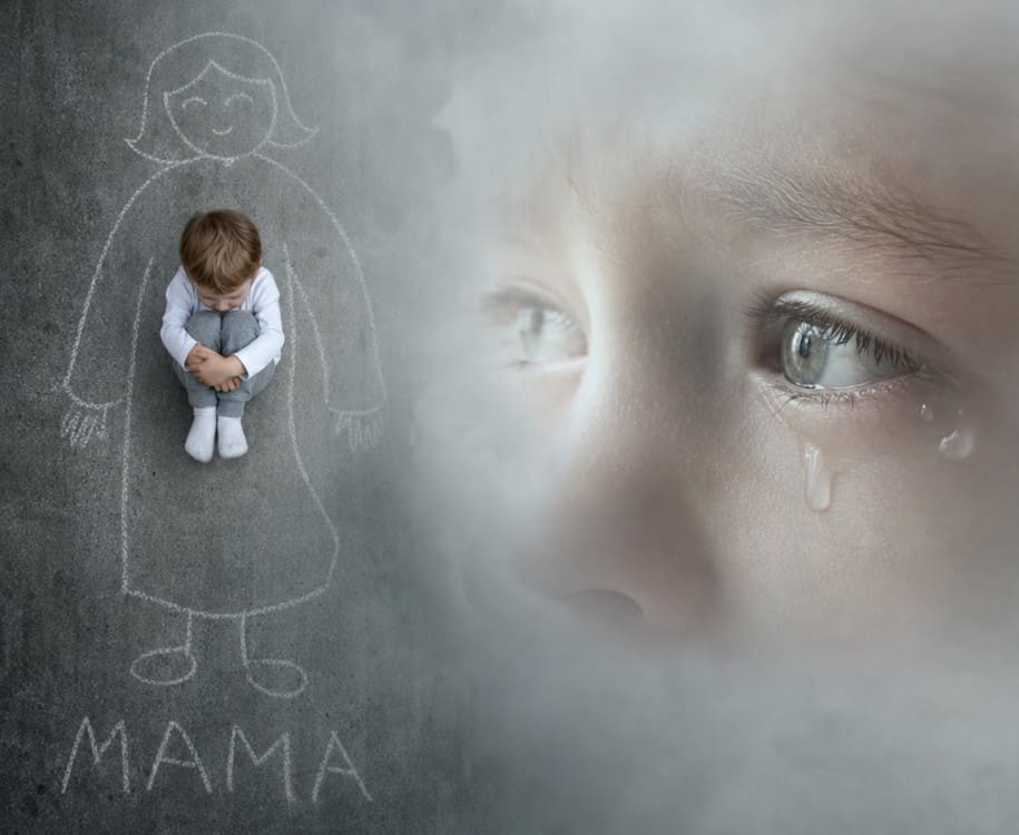 дошкольник сидит на асфальте, рядом рисунок мамы